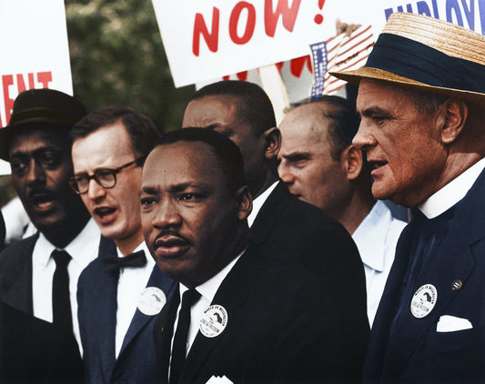 Martin Luther King standing in a black suit next to other civil rights activist